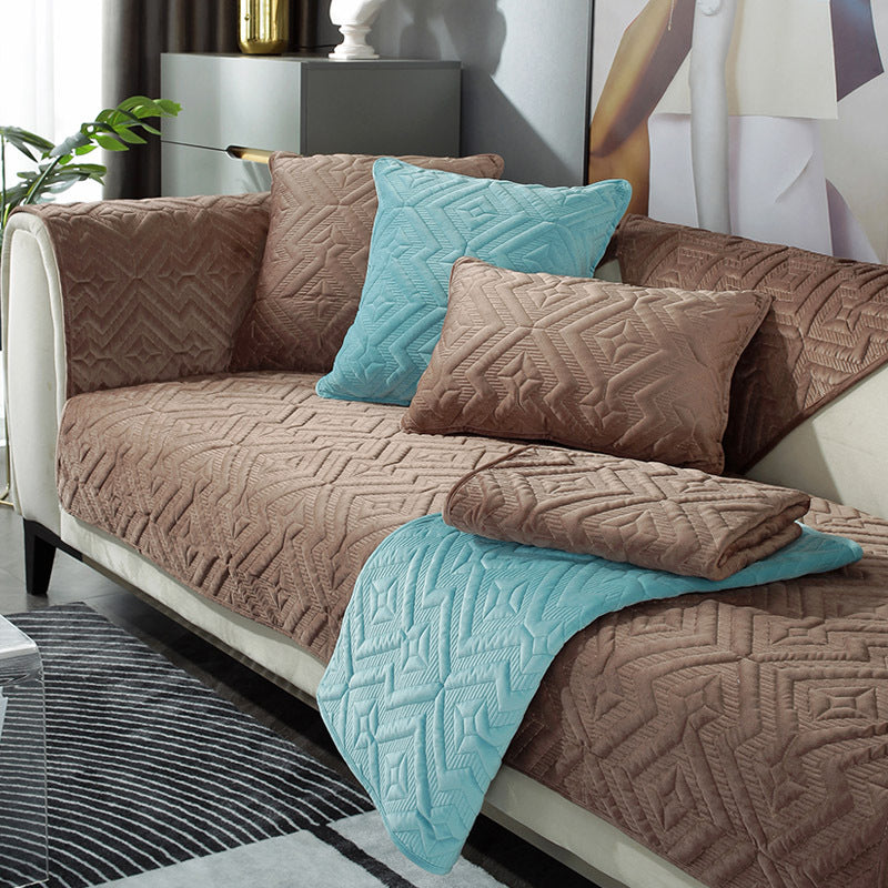 Black plush winter sofa cushion on a leather sofa with thick quilted texture