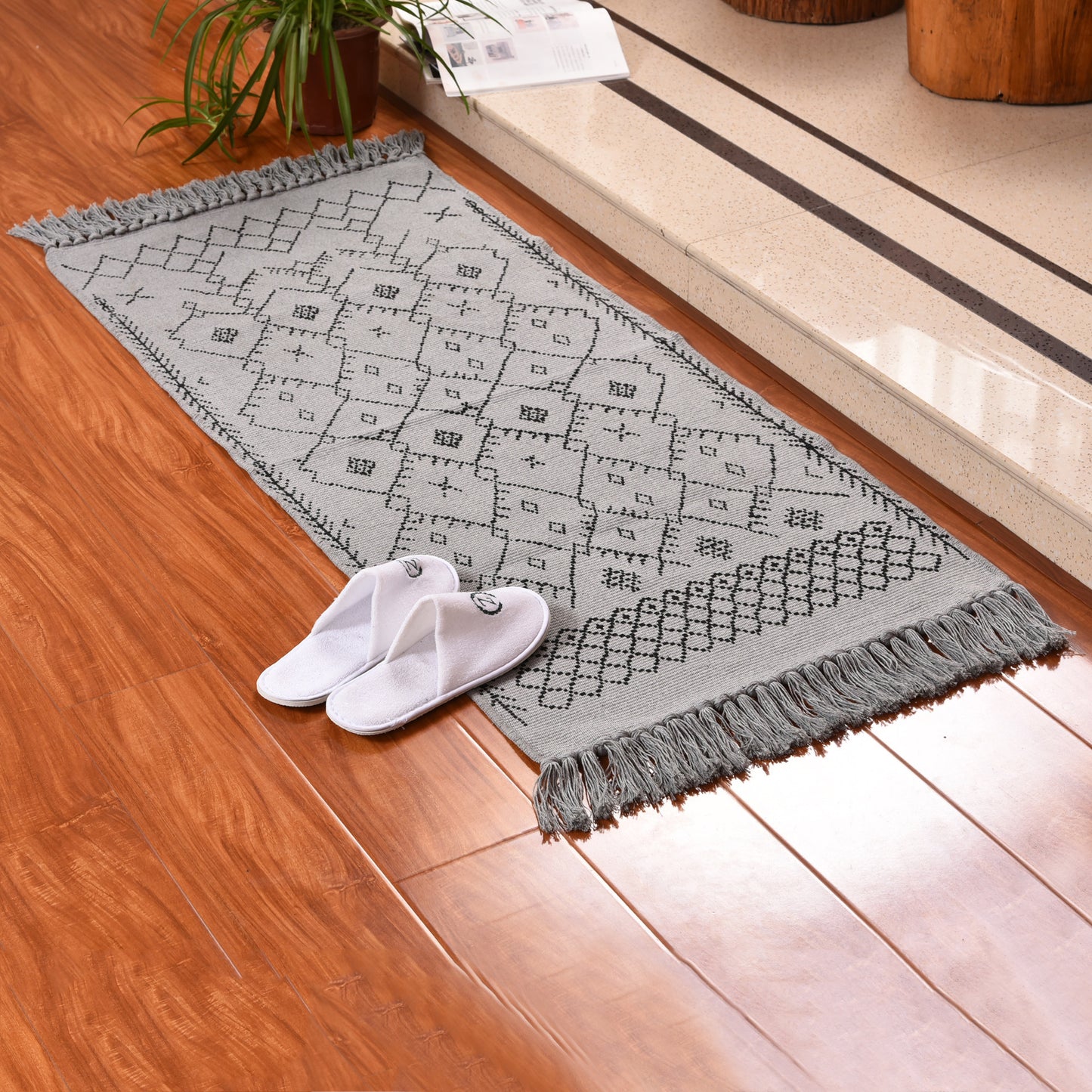 Cotton braided black printed carpet mat on a wooden floor in a minimalist room setting