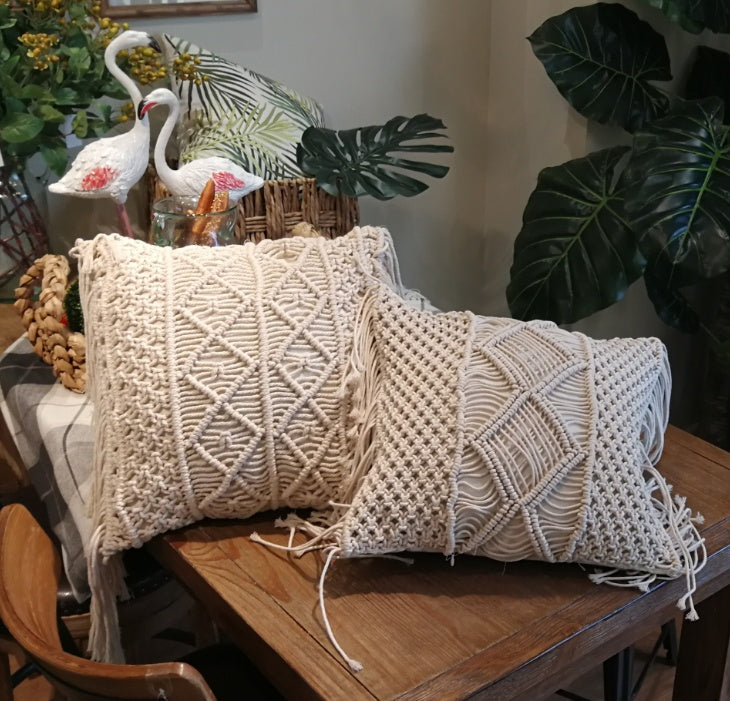 Hand-woven macrame cotton cushion cover on a rustic wooden bench with boho décor
