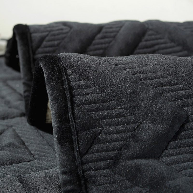 Black plush winter sofa cushion on a leather sofa with thick quilted texture