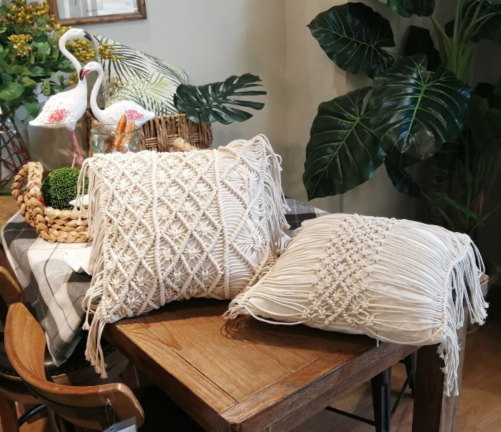 Hand-woven macrame cotton cushion cover on a rustic wooden bench with boho décor