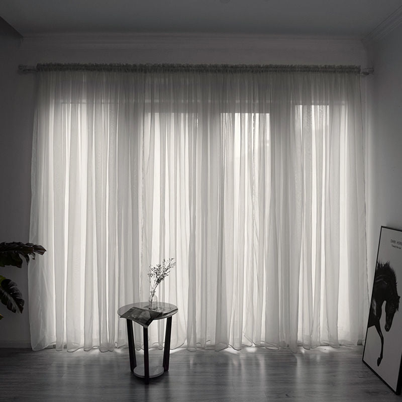 Modern solid color sheer gauze curtain on a balcony window filtering soft light