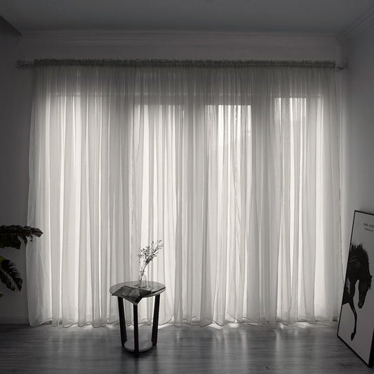 Modern solid color sheer gauze curtain on a balcony window filtering soft light