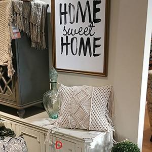 Hand-woven macrame cotton cushion cover on a rustic wooden bench with boho décor