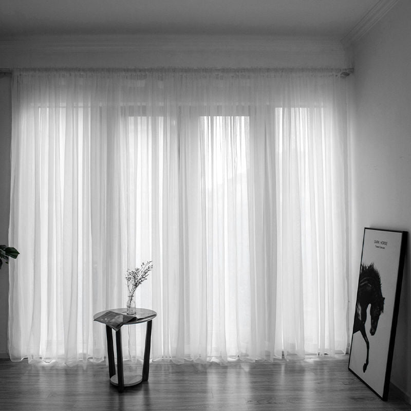 Modern solid color sheer gauze curtain on a balcony window filtering soft light
