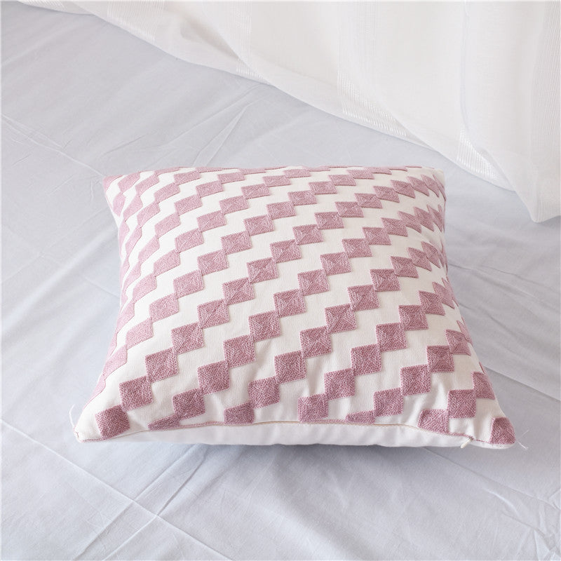 Geometric embroidered cotton pillowcase on a modern sofa with decorative cushions