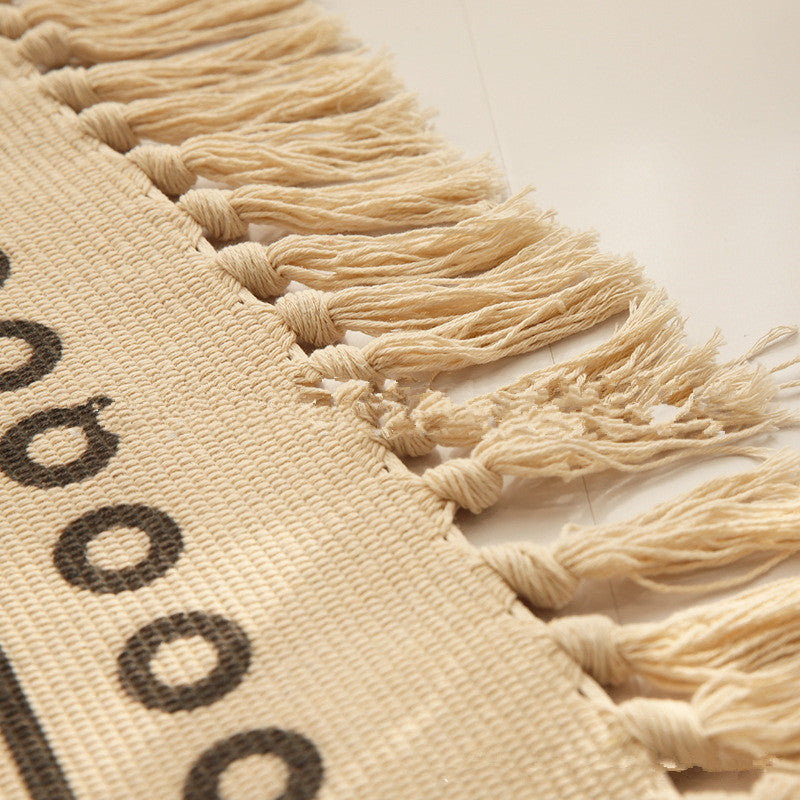 Woven tassel carpet placed in a cozy living room with neutral furniture and boho accents