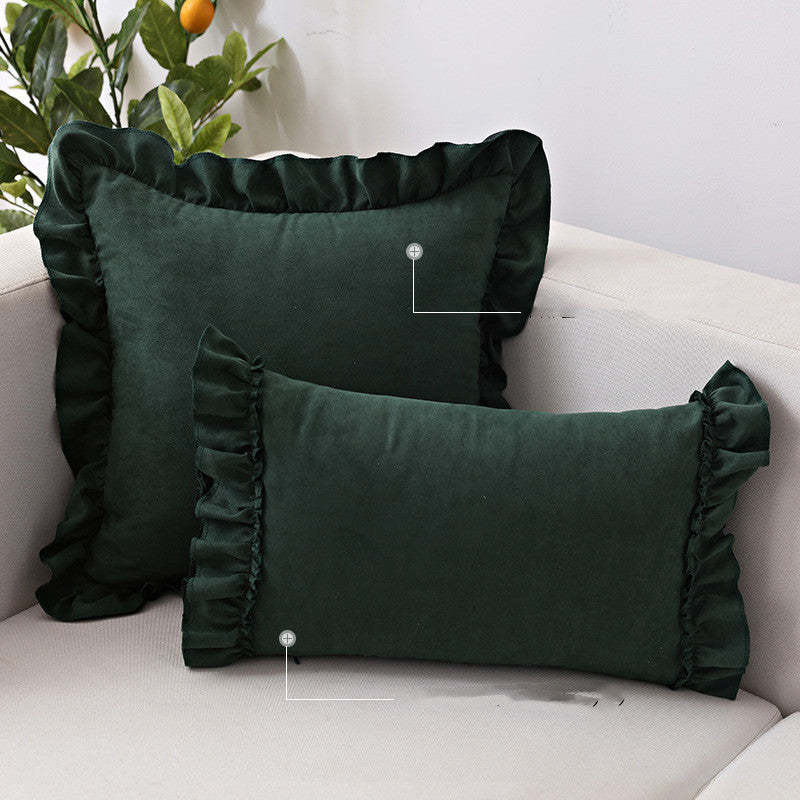 Small suede cushion pillowcase placed on a sofa beside a neutral-toned bed setup