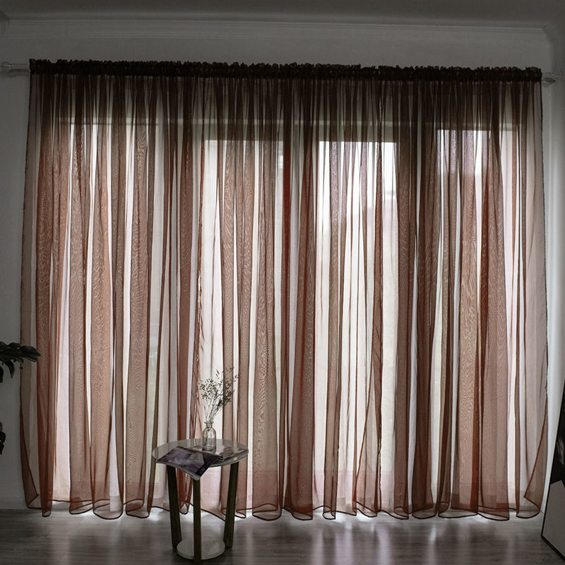 Modern solid color sheer gauze curtain on a balcony window filtering soft light