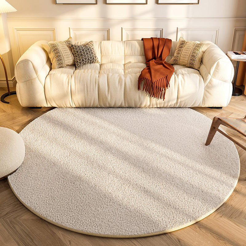 New round carpet placed in a modern living room under a coffee table with neutral décor