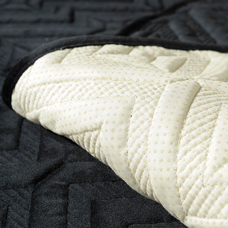 Black plush winter sofa cushion on a leather sofa with thick quilted texture

