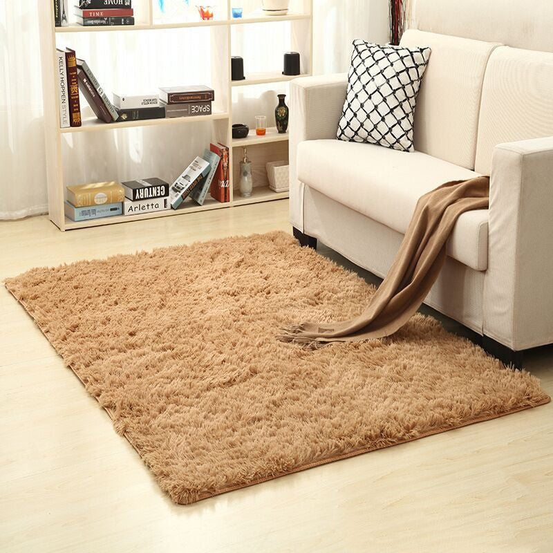 Soft carpet spread in a cozy living room with a sofa and coffee table beside a sunny bedroom corner

