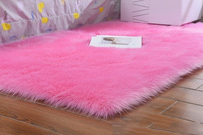 Oval wool-like carpet placed in a bedroom near the bed with cozy home décor

