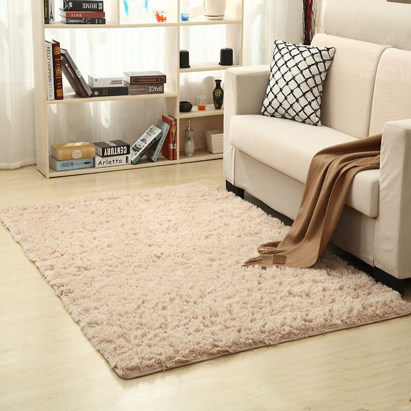 Soft carpet spread in a cozy living room with a sofa and coffee table beside a sunny bedroom corner


