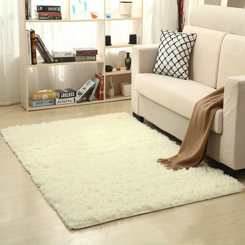 Soft carpet spread in a cozy living room with a sofa and coffee table beside a sunny bedroom corner

