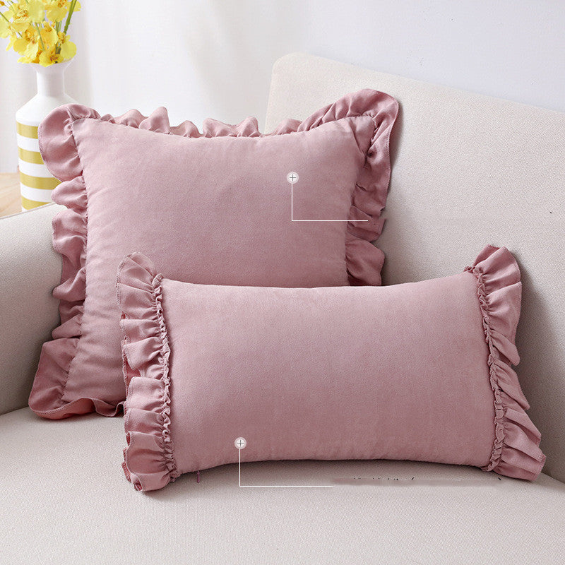 Small suede cushion pillowcase placed on a sofa beside a neutral-toned bed setup

