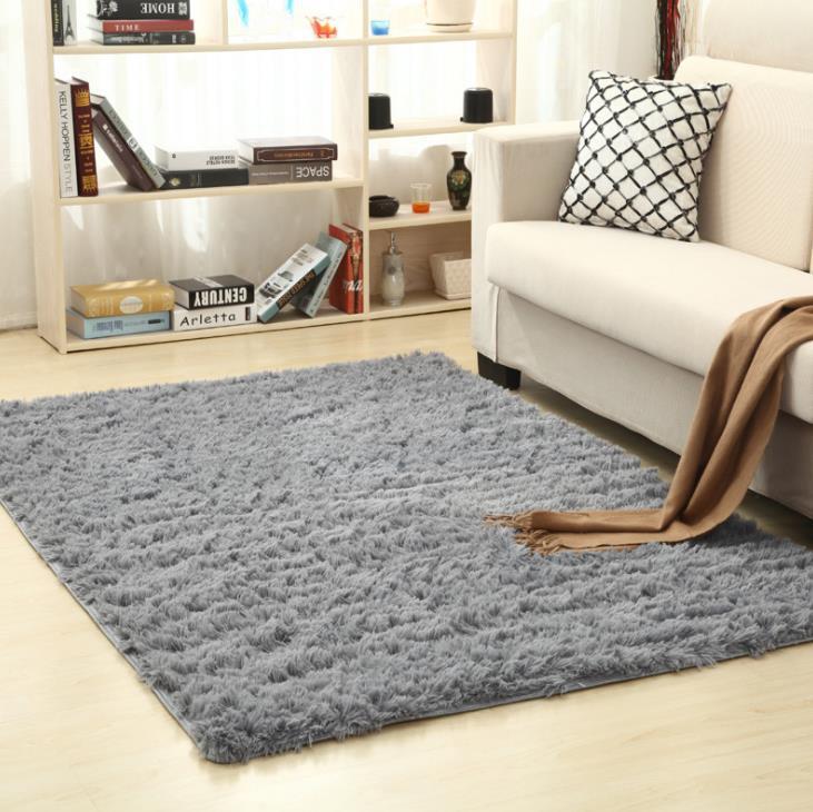 Soft carpet spread in a cozy living room with a sofa and coffee table beside a sunny bedroom corner

