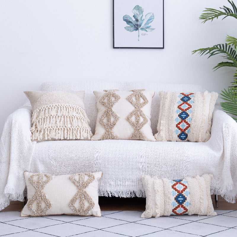 Tufted Moroccan fringed waist pillow on a boho-style sofa with cozy textures

