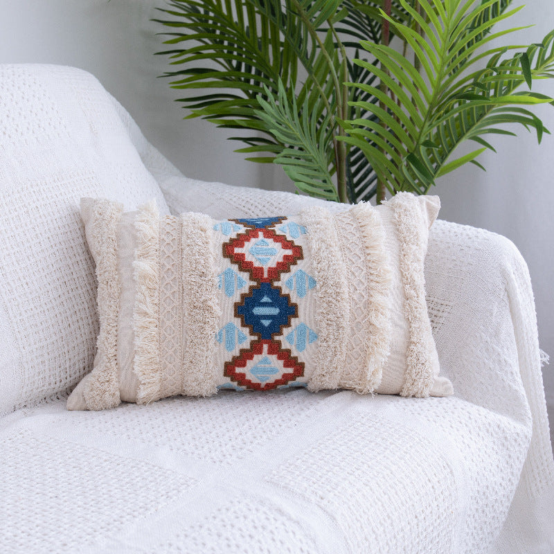 Tufted Moroccan fringed waist pillow on a boho-style sofa with cozy textures

