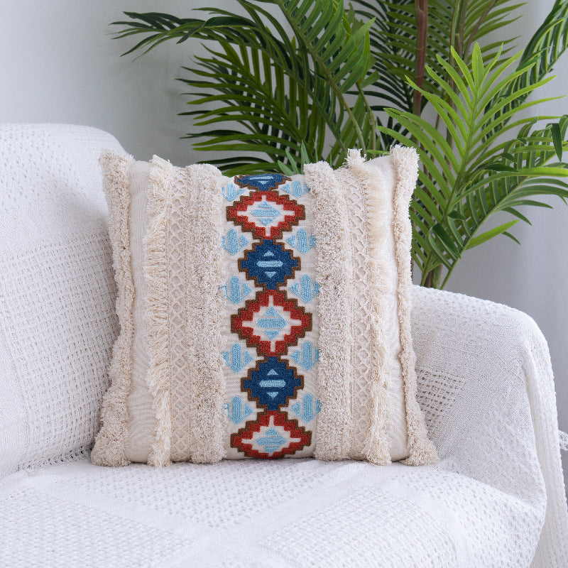 Tufted Moroccan fringed waist pillow on a boho-style sofa with cozy textures

