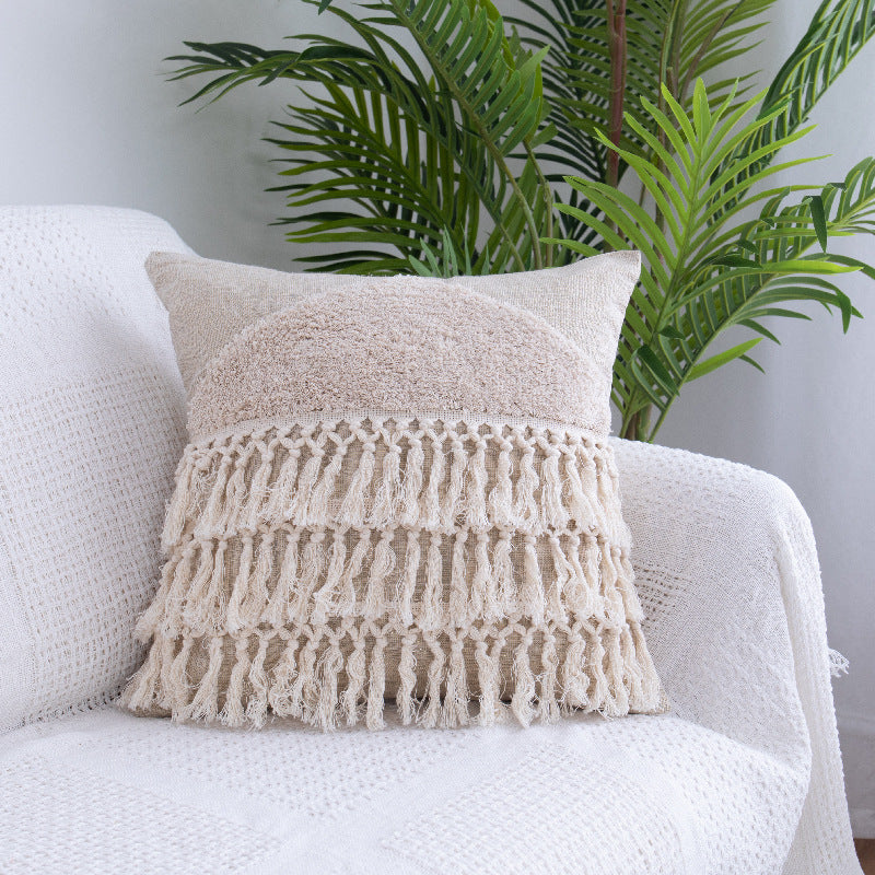 Tufted Moroccan fringed waist pillow on a boho-style sofa with cozy textures

