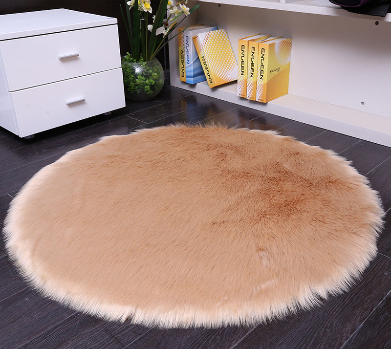 Round faux sheepskin white rug placed beside a bed on a wooden floor in a cozy bedroom

