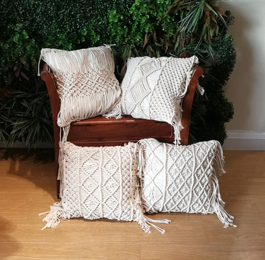 Hand-woven macrame cotton cushion cover on a rustic wooden bench with boho décor

