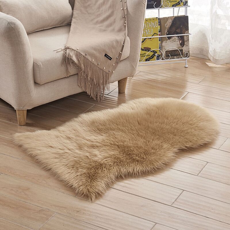 Plush carpet floor mat placed in a bedroom near the bed on a wooden floor

