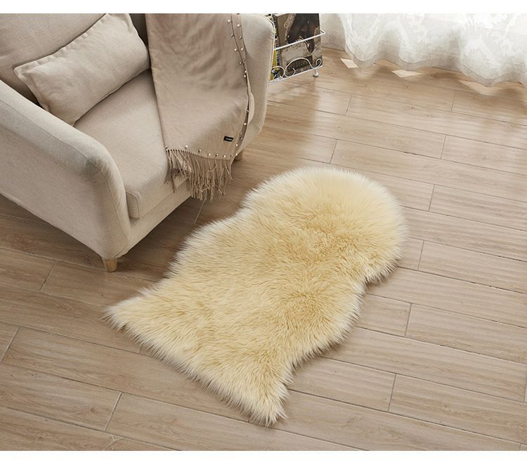 Plush carpet floor mat placed in a bedroom near the bed on a wooden floor

