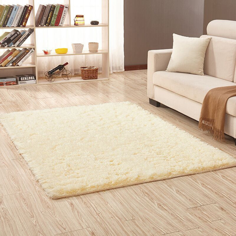Soft carpet spread in a cozy living room with a sofa and coffee table beside a sunny bedroom corner

