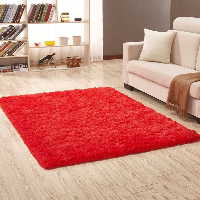 Soft carpet spread in a cozy living room with a sofa and coffee table beside a sunny bedroom corner

