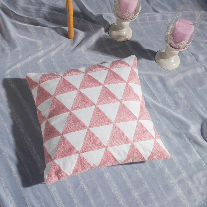 Geometric embroidered cotton pillowcase on a modern sofa with decorative cushions

