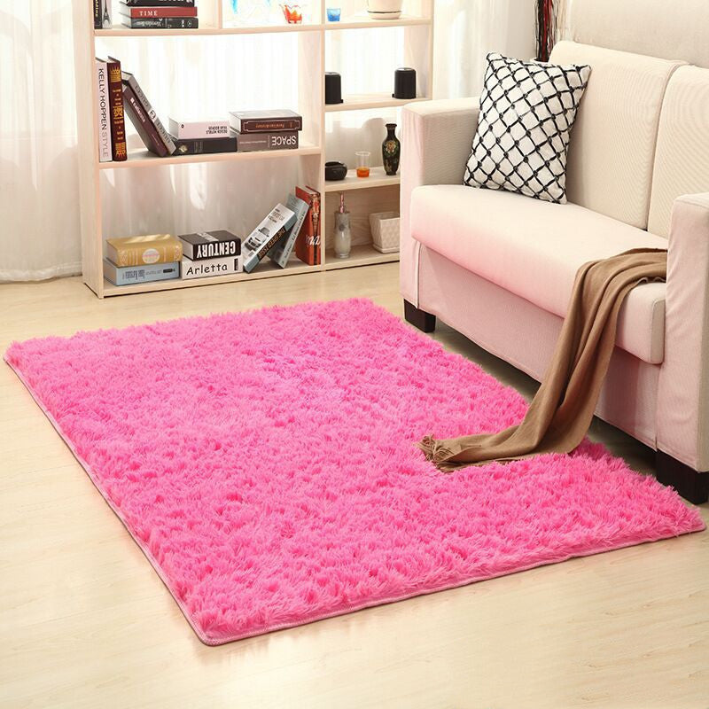 Soft carpet spread in a cozy living room with a sofa and coffee table beside a sunny bedroom corner


