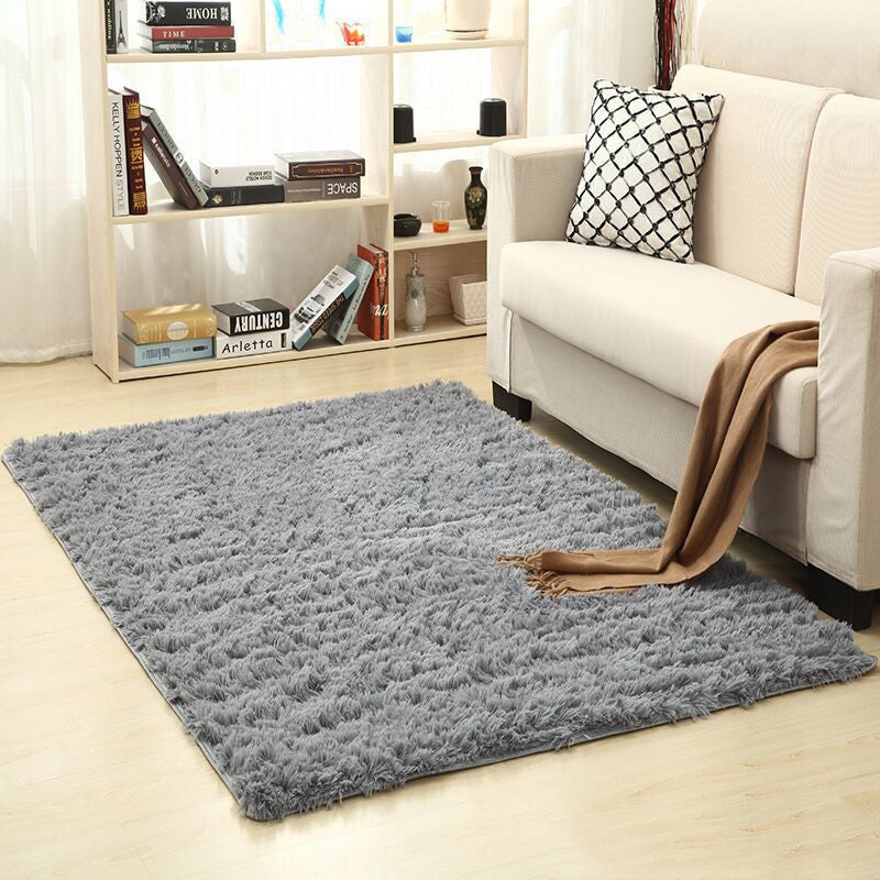 Soft carpet spread in a cozy living room with a sofa and coffee table beside a sunny bedroom corner

