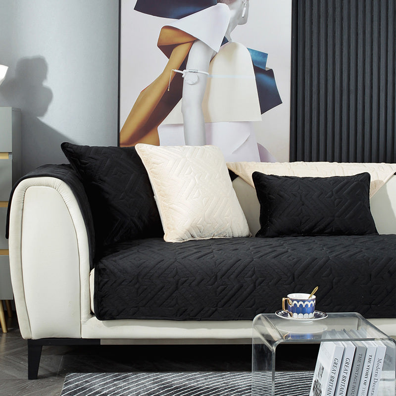 Black plush winter sofa cushion on a leather sofa with thick quilted texture

