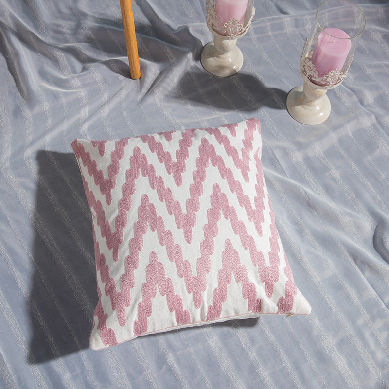 Geometric embroidered cotton pillowcase on a modern sofa with decorative cushions

