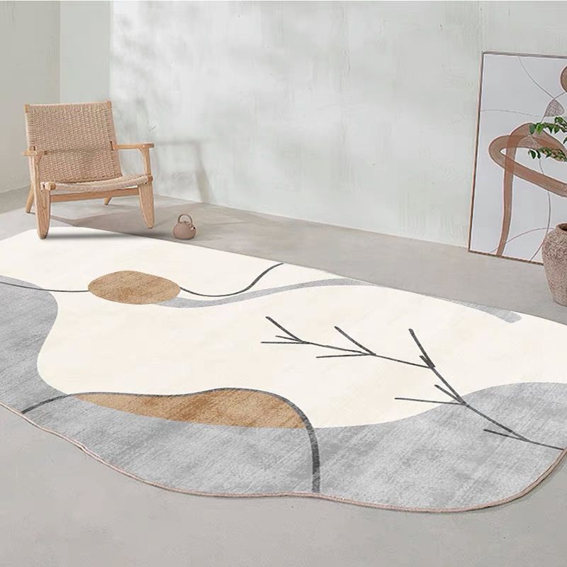 Irregular shaped carpet placed under a coffee table in a modern living room with artistic décor

