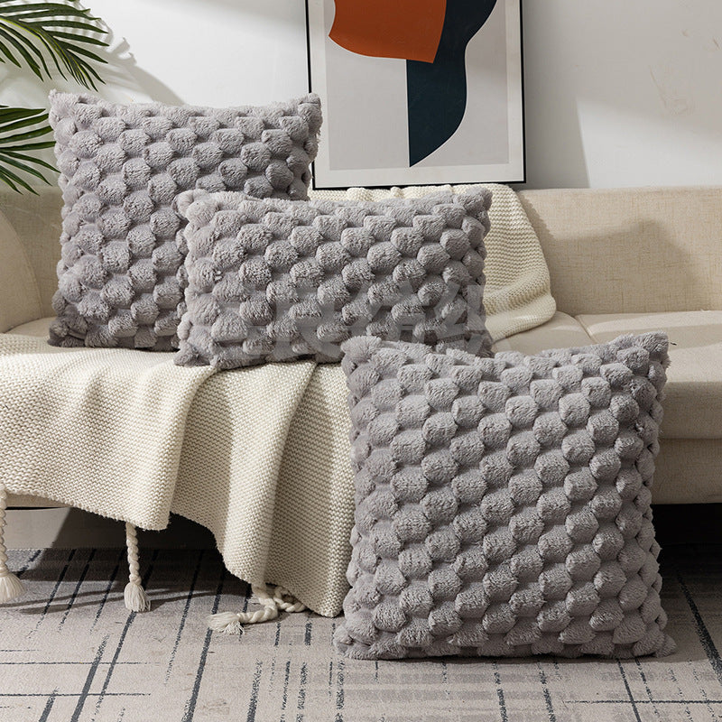 Woven fleece solid color waist pillow cover on a soft grey sofa in a cozy room

