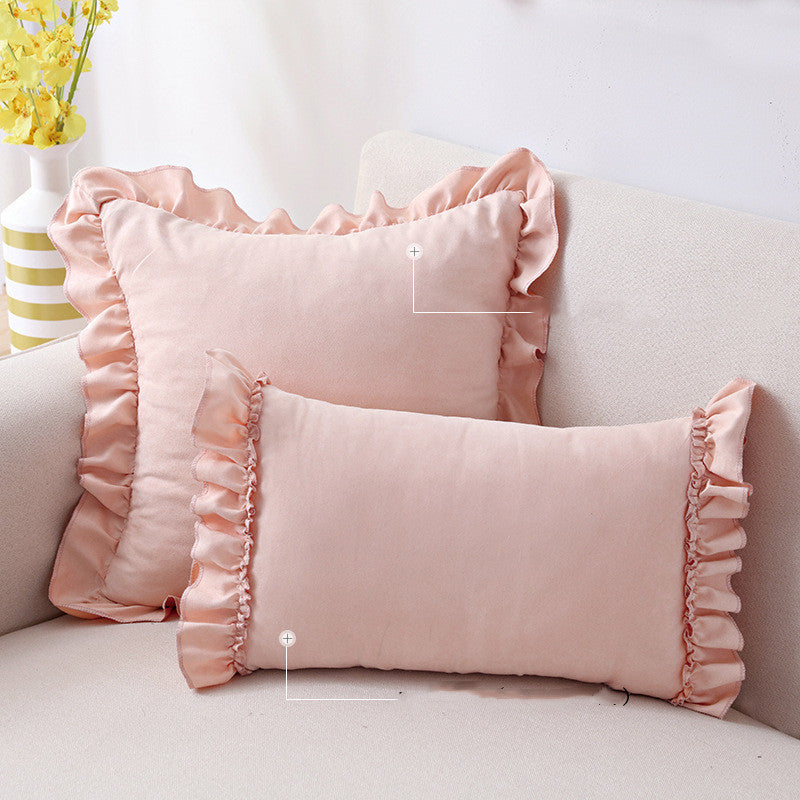 Small suede cushion pillowcase placed on a sofa beside a neutral-toned bed setup

