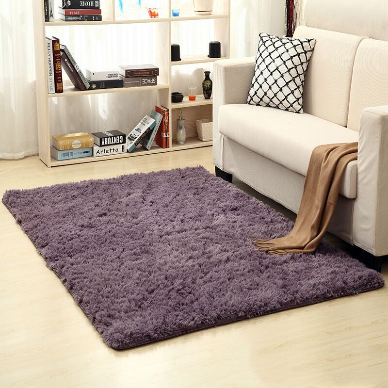 Soft carpet spread in a cozy living room with a sofa and coffee table beside a sunny bedroom corner

