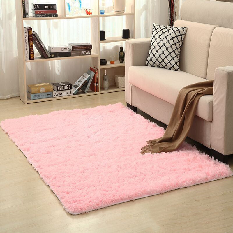 Soft carpet spread in a cozy living room with a sofa and coffee table beside a sunny bedroom corner

