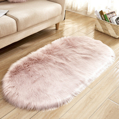 Oval wool-like carpet placed in a bedroom near the bed with cozy home décor

