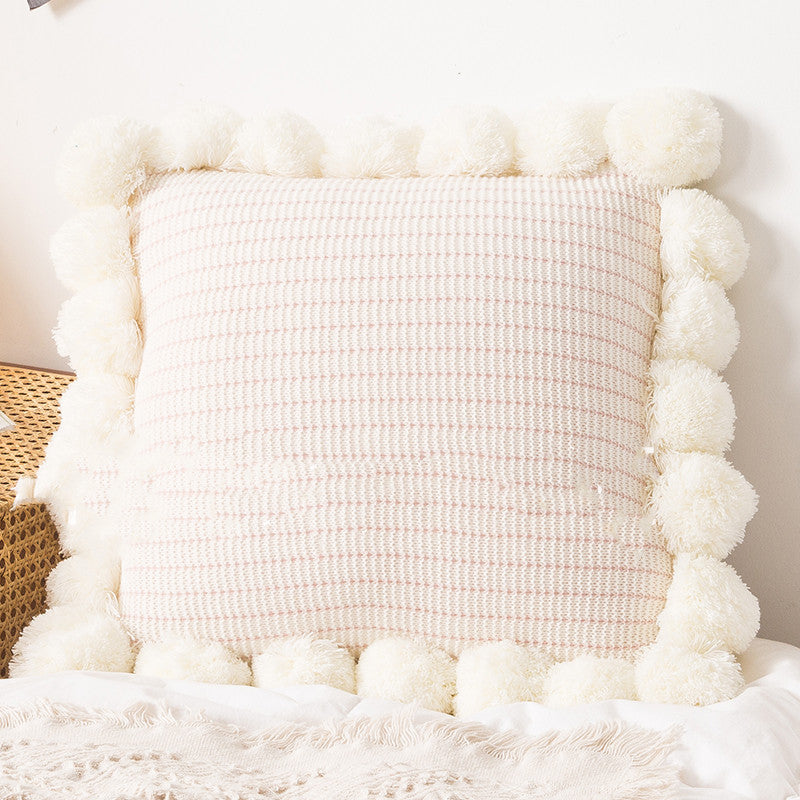 Knitted waist pillowcase on a neutral-toned bed with cozy decorative pillows

