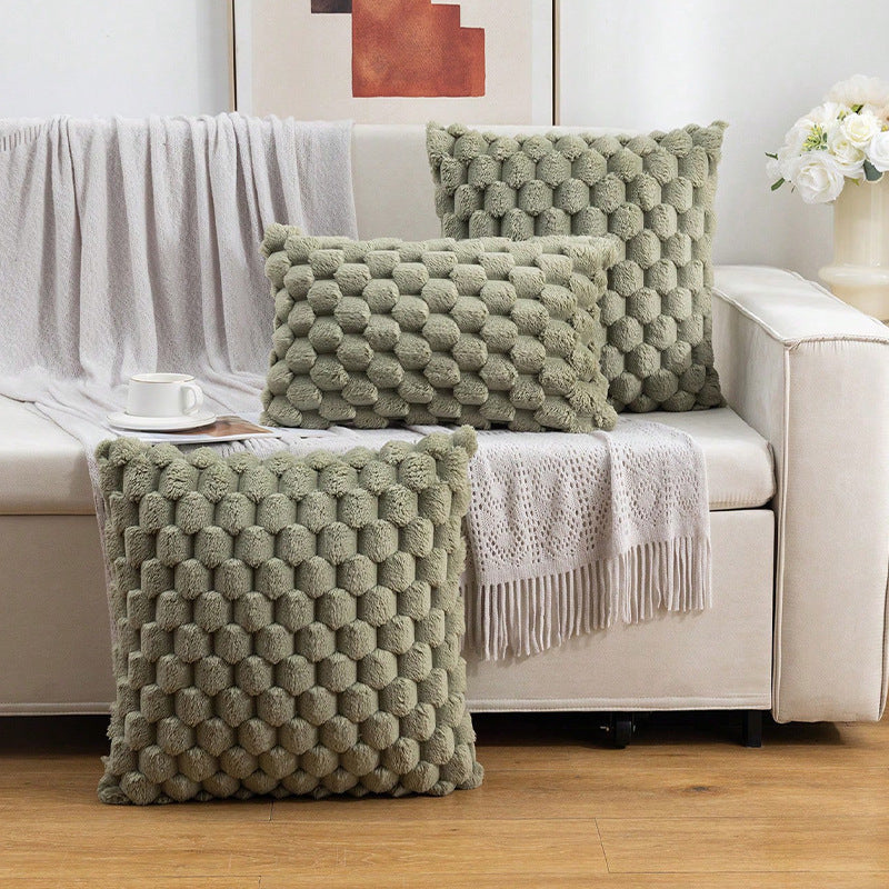Woven fleece solid color waist pillow cover on a soft grey sofa in a cozy room

