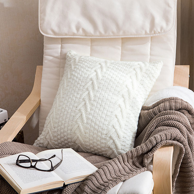Thick wool knitted pillowcase with chunky knit pattern on a cozy sofa

