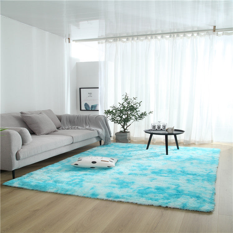 Tie-dye gradient rug with long wool texture beside a bed and end table in a modern bedroom

