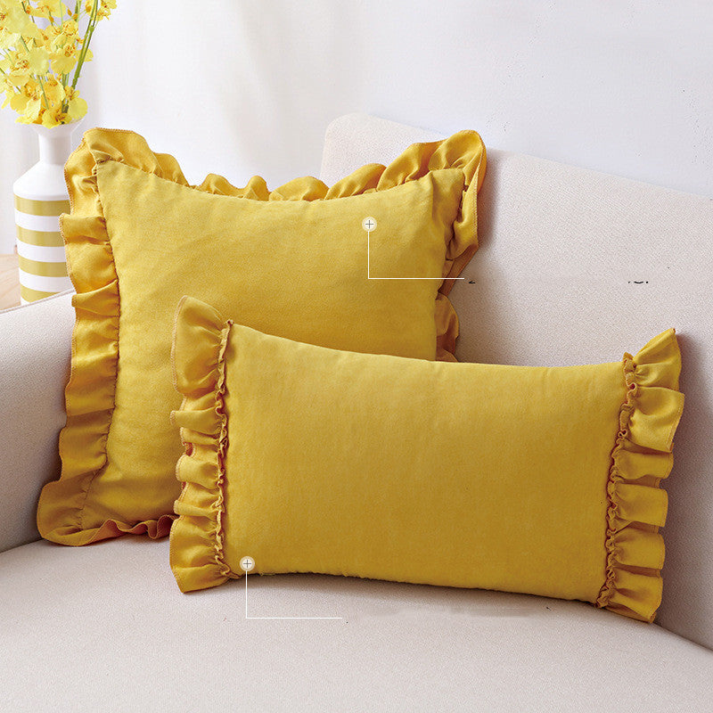 Small suede cushion pillowcase placed on a sofa beside a neutral-toned bed setup


