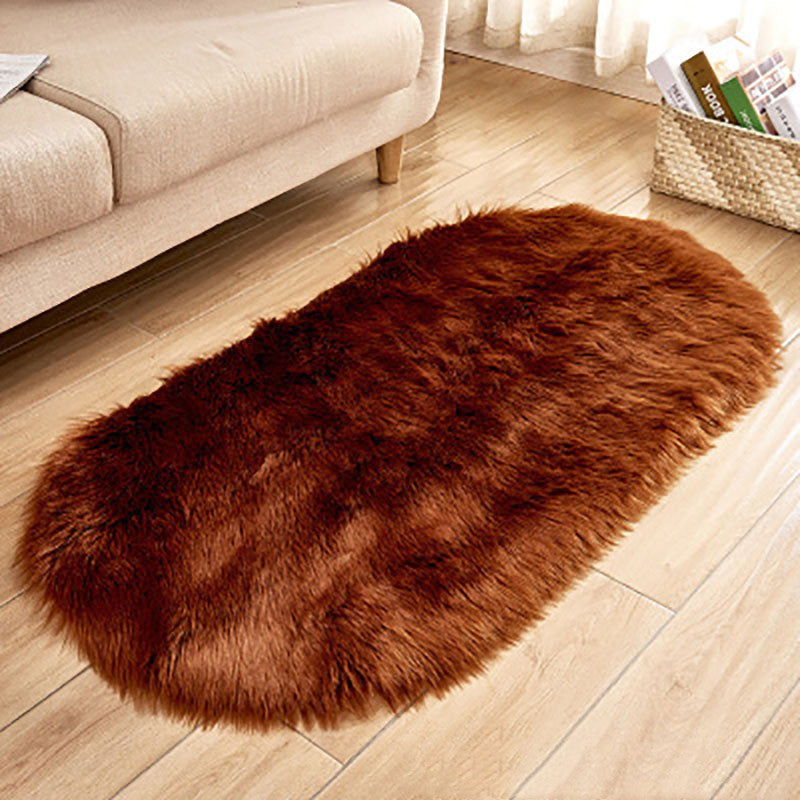 Oval wool-like carpet placed in a bedroom near the bed with cozy home décor

