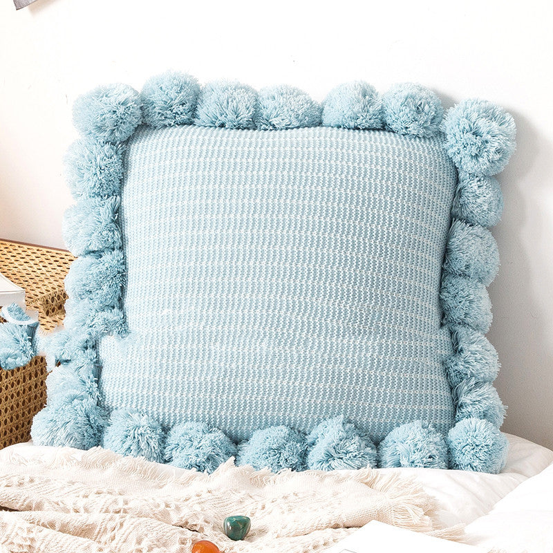 Knitted waist pillowcase on a neutral-toned bed with cozy decorative pillows


