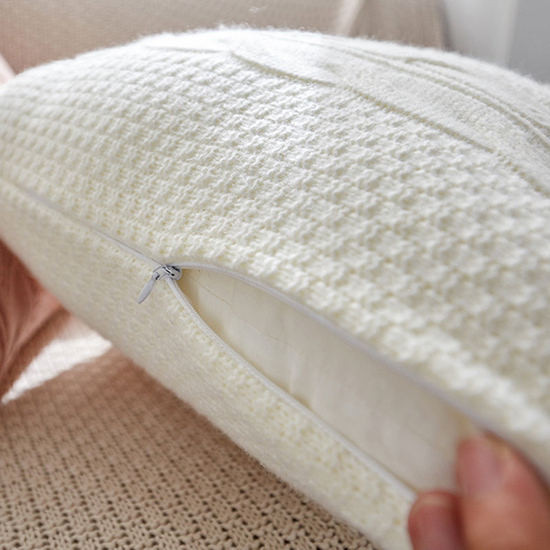 Natural wool pillow placed on a bed with neutral, minimalist bedding

